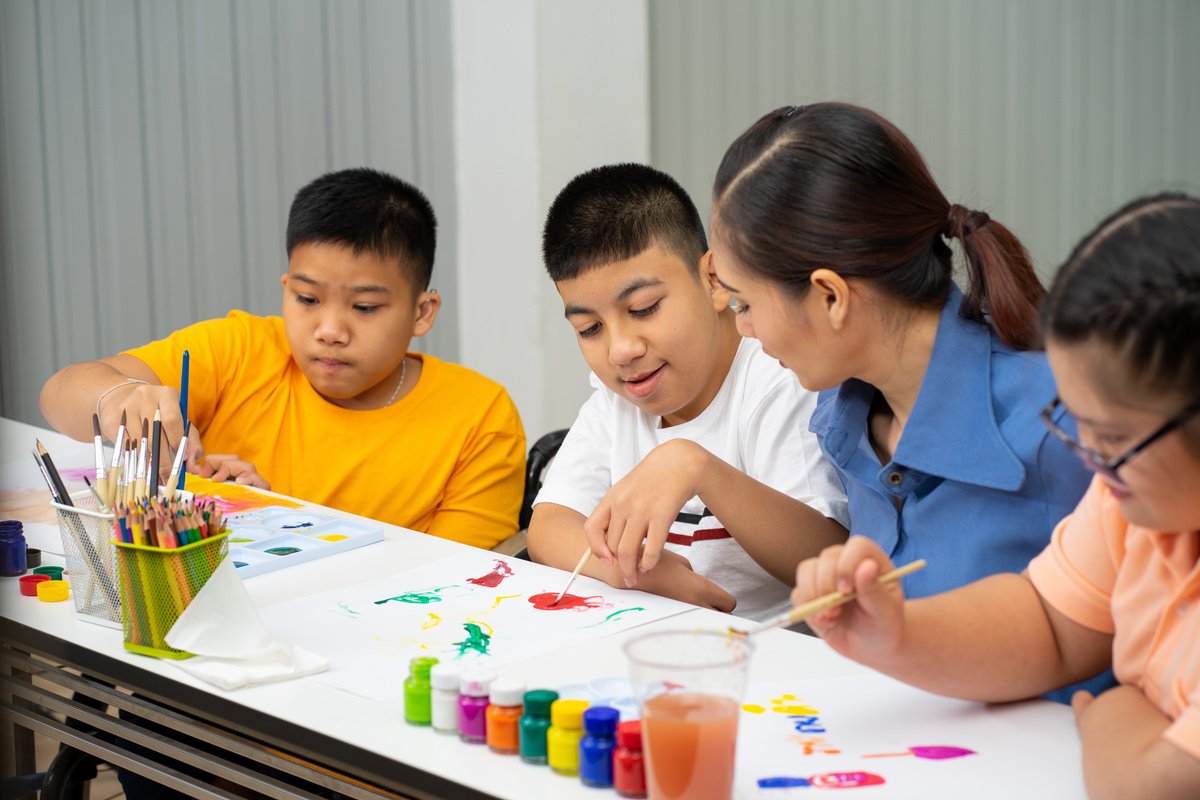  disability children with Autism girl learning color paint 